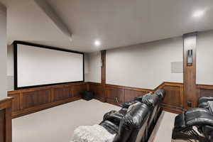 Home theater with wooden walls and carpet floors