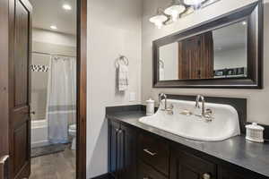 Full bathroom featuring vanity, toilet, wood-type flooring, and shower / tub combo