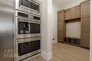 Kitchen featuring light brown cabinets, light wood-type flooring, and appliances with stainless steel finishes