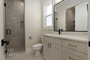 Bathroom featuring vanity, an enclosed shower, and toilet