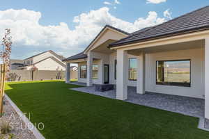 Rear view of property with a yard and a patio area