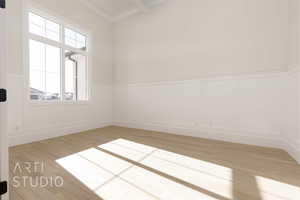 Spare room featuring light hardwood / wood-style floors and beam ceiling