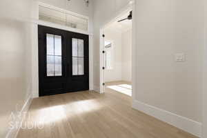 Foyer with ceiling fan, light hardwood / wood-style floors, and french doors