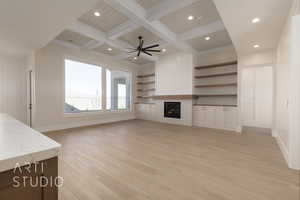 Unfurnished living room with coffered ceiling, ceiling fan, crown molding, beam ceiling, and light hardwood / wood-style flooring