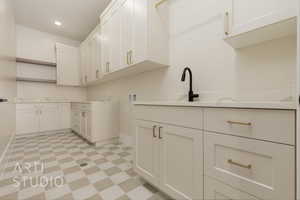 Clothes washing area featuring cabinets and hookup for a washing machine