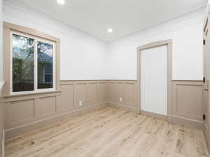 Unfurnished room with light wood-type flooring and crown molding