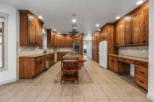 Kitchen featuring recessed lighting, a sink, decorative backsplash, light tile patterned flooring, and appliances with stainless steel finishes