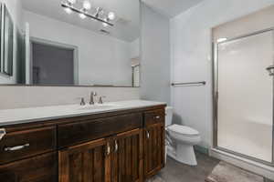 Bathroom featuring toilet, visible vents, and a shower stall
