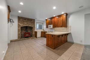 Kitchen with light tile patterned floors, recessed lighting, a peninsula, and white appliances