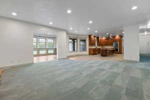 Unfurnished living room featuring recessed lighting, light carpet, and baseboards