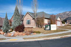 Obstructed view of property featuring a mountain view, a front lawn, and a garage