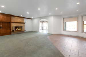 Unfurnished living room with a fireplace and light carpet