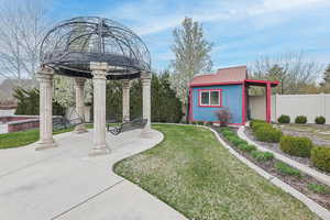 View of yard featuring an outdoor structure, a patio, and fence
