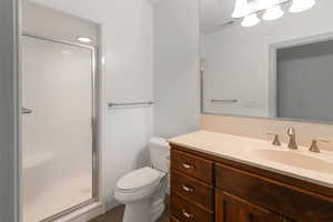 Bathroom with vanity, toilet, and a shower with shower door