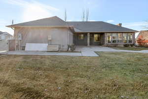 Rear view of property featuring a patio and a lawn