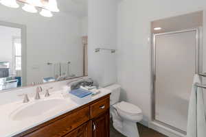 Bathroom with tile patterned floors, vanity, toilet, and a shower with door