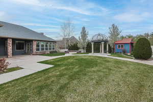 View of yard with a patio, a jacuzzi, and an outdoor structure