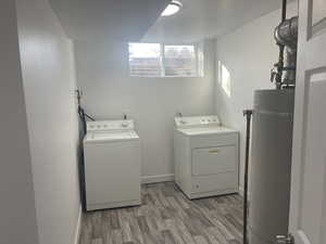 Laundry area featuring washer and clothes dryer, dark wood-type flooring, and water heater