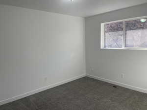 Unfurnished room with dark carpet