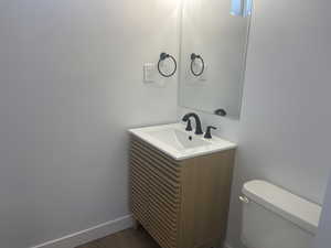 Bathroom with vanity, hardwood / wood-style flooring, and toilet