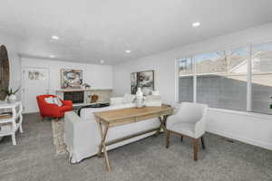 Living room featuring a tile fireplace, carpet flooring, and a textured ceiling