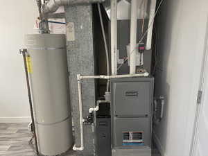 Utility room featuring secured water heater and heating unit