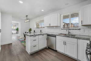 Kitchen with sink, decorative light fixtures, stainless steel appliances, and white cabinets