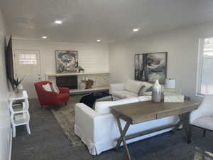 Carpeted living room with a textured ceiling