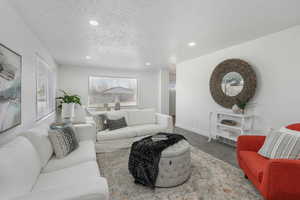 Carpeted living room featuring a textured ceiling