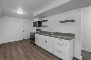 Kitchen featuring dark hardwood / wood-style flooring, sink, stainless steel appliances, and white cabinets