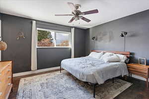 Bedroom with dark hardwood / wood-style floors and ceiling fan