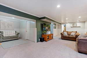 Carpeted living room with ornamental molding and a textured ceiling