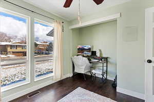 Office with ceiling fan and dark wood-type flooring