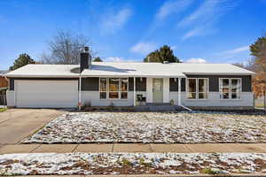 Ranch-style home featuring covered porch and a garage