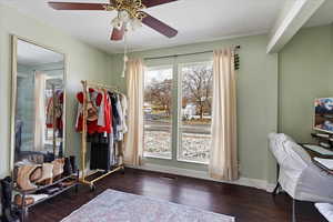 Interior space with ceiling fan and dark hardwood / wood-style floors