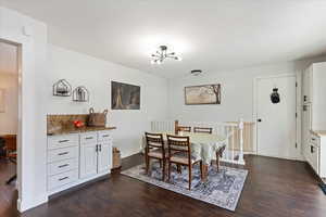 Dining space with dark hardwood / wood-style flooring and a chandelier