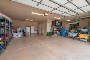 Garage featuring white fridge and a garage door opener