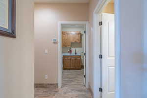 Hallway with light hardwood / wood-style flooring and sink