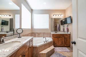 Bathroom with vanity, tile patterned floors, and independent shower and bath