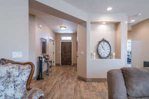 Hall with hardwood / wood-style floors and a textured ceiling