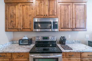 Kitchen featuring light stone countertops and appliances with stainless steel finishes