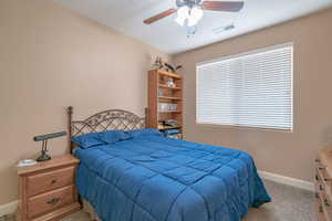 Bedroom with ceiling fan and light colored carpet