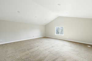 Bonus room featuring carpet flooring and lofted ceiling