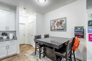 Dining area with a textured ceiling and dark wood-type flooring