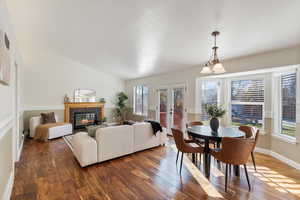 Dining space featuring french doors, dark hardwood / wood-style flooring, lofted ceiling, and a notable chandelier