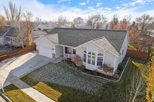 Ranch-style home featuring a porch, a garage, and a front lawn