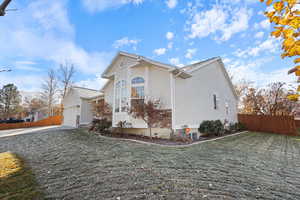 View of side of home featuring a yard and a garage