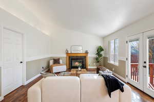 Living room featuring dark hardwood / wood-style flooring and lofted ceiling