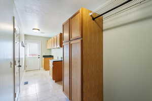 Kitchen featuring light tile patterned flooring and a textured ceiling