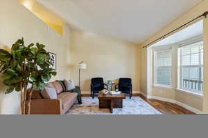 Living room with hardwood / wood-style floors and lofted ceiling